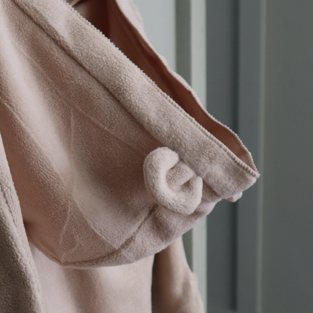 Close-up of a beige fleece jacket with a blurred background