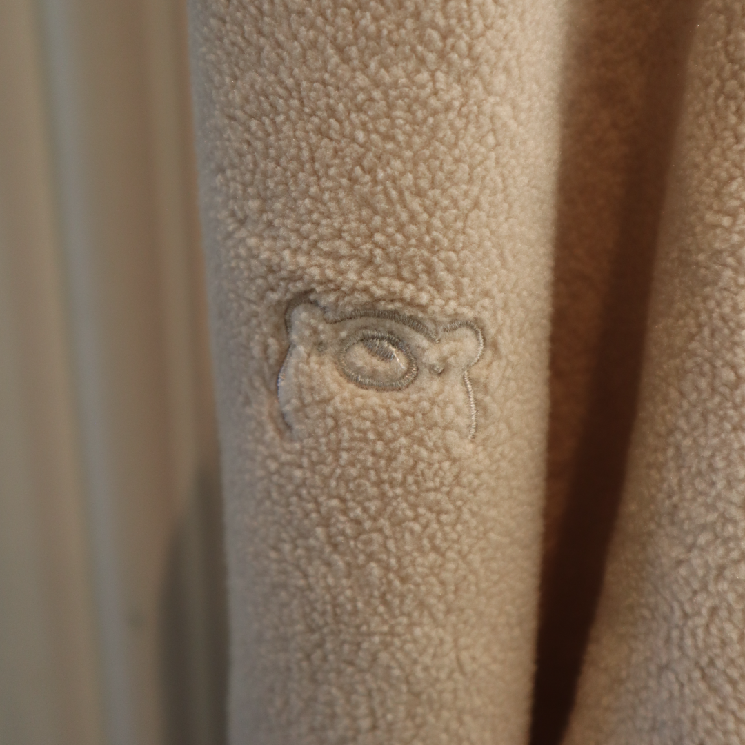 Textured beige surface with a subtle embossed design of an eye.