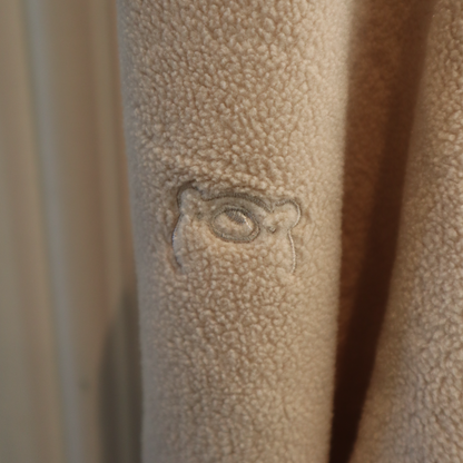 Textured beige surface with a subtle embossed design of an eye.